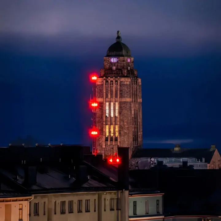 Kallion kirkon torni punaisine valoineen sinisen hetken taivasta vasten