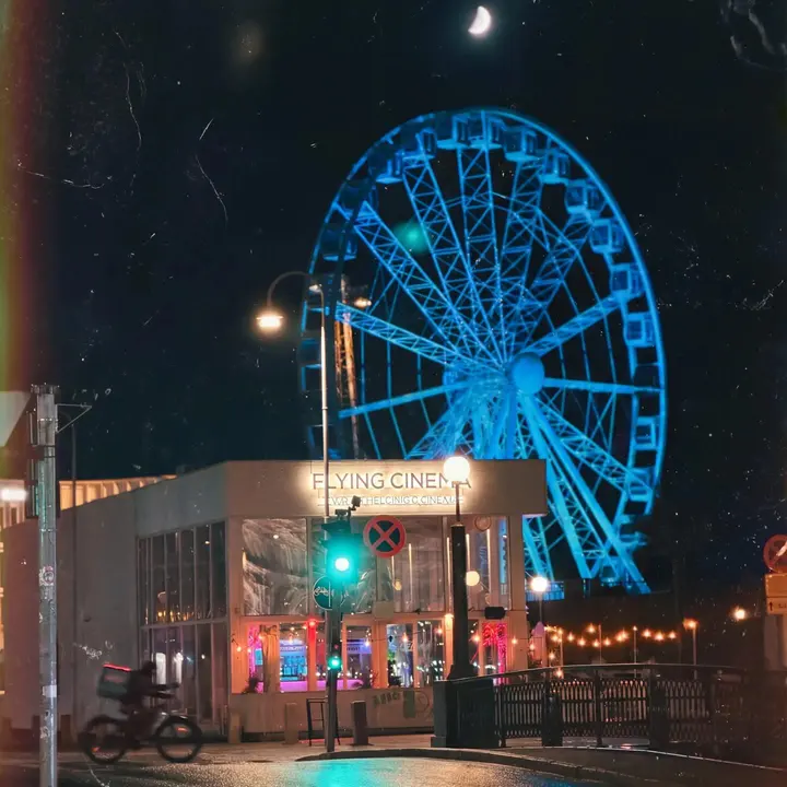 Sinisenä valaistu SkyWheel-maailmanpyörä Katajanokan yössä