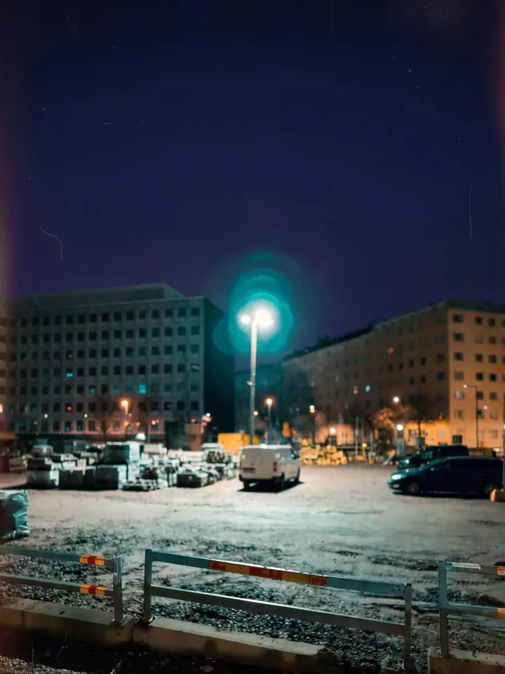 Talvinen työmaa-aukio ja rakennuksia katulampun alla